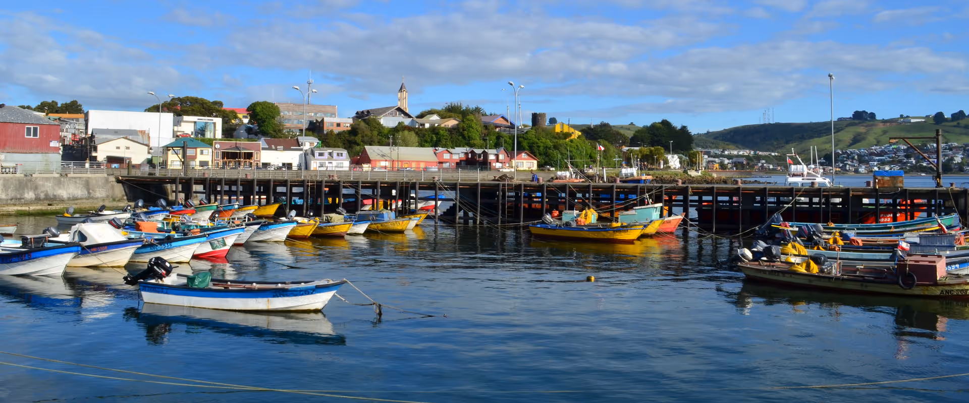 Botes y muelle Pudeto de Ancud en un día soleado